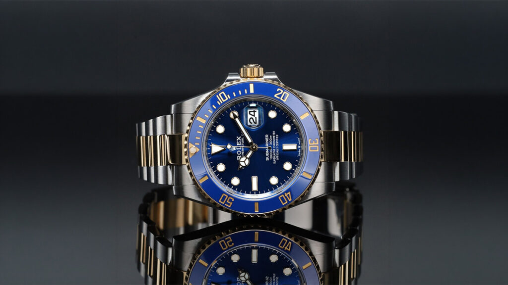 a rolex submariner date on its side on reflective surface